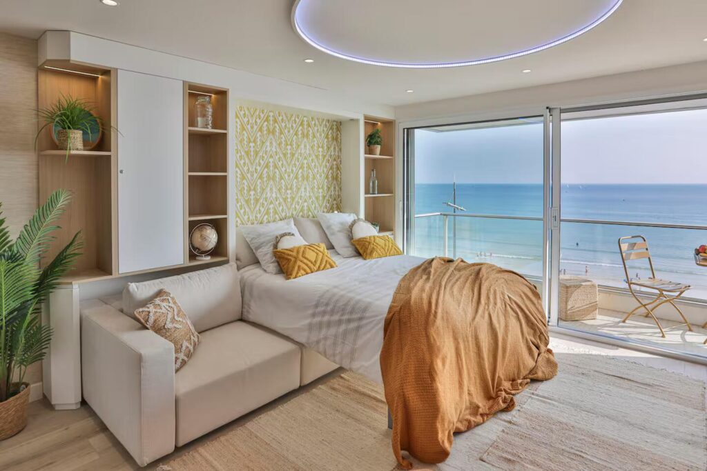 Optimisation d'espace par Studio Vesta avec une armoire-lit escamotable offrant un couchage haut de gamme face à la mer.