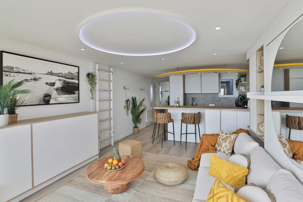 Aménagement intérieur multifonction incluant une cuisine moderne, un bar avec tabourets tressés et un espalier de sport en bois design.