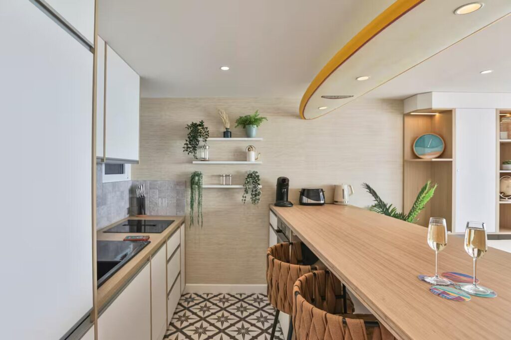 Zoom sur le sol de la cuisine en carreaux de ciment à motifs géométriques, contrastant avec le parquet clair du salon.