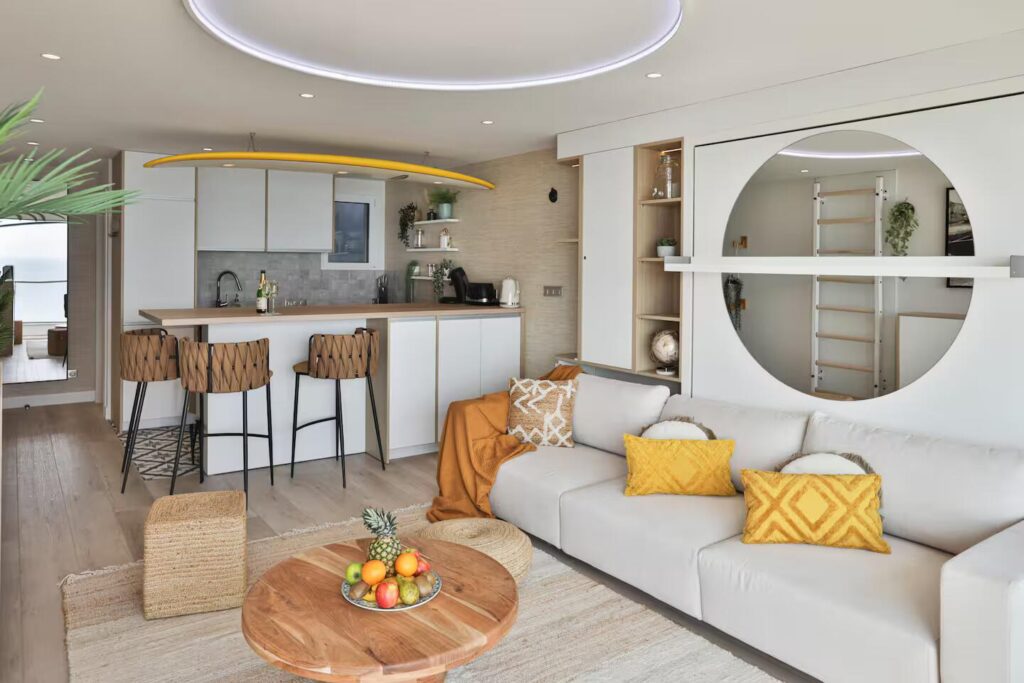 Cuisine ouverte avec comptoir dînatoire et élément décoratif fort : une planche de surf suspendue au plafond intégrant des luminaires.