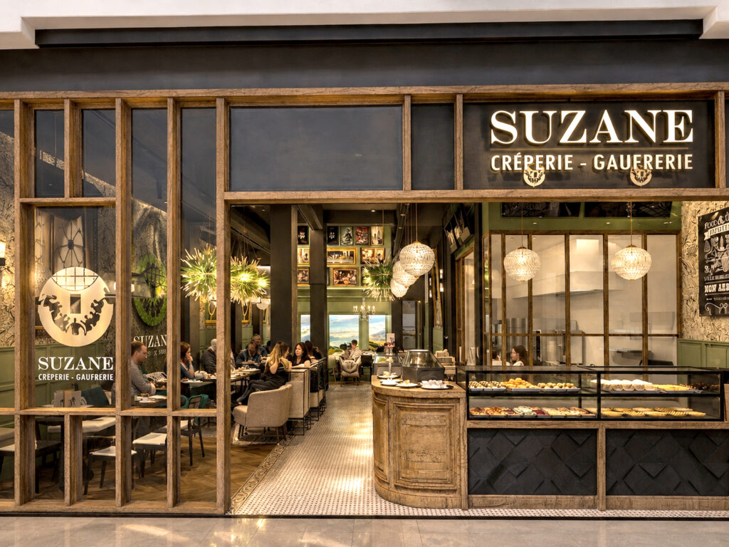 Façade commerciale en bois massif et vitrines éclairées du restaurant Suzane Crêperie Gaufrerie conçu par Studio Vesta.