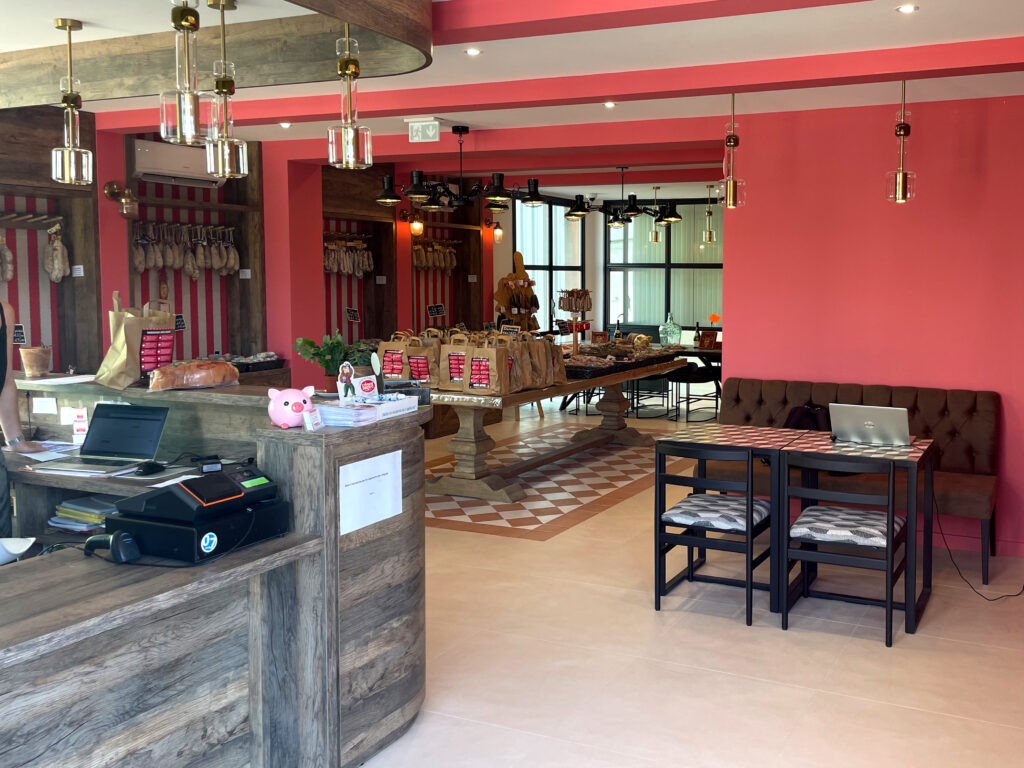 Concept retail "Face Mer" décliné en boutique avec un large pôle d'accueil en bois, une zone de dégustation avec banquette capitonnée et des suspensions design en verre et laiton.