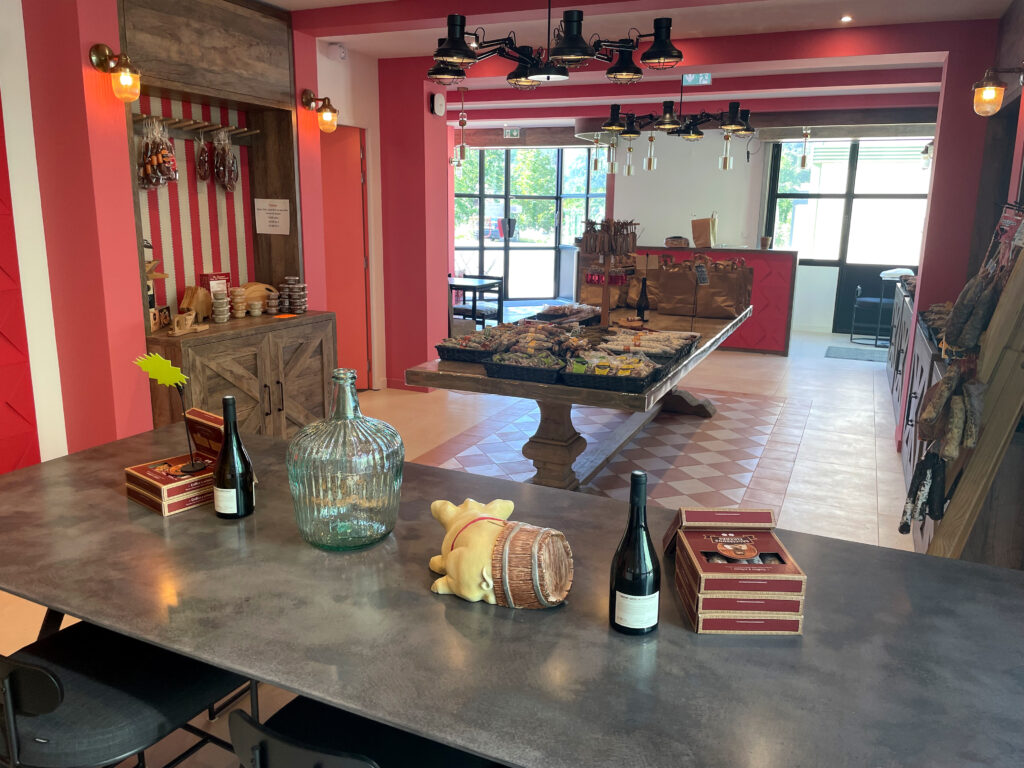 Concept retail "Face Mer" décliné en boutique avec un large pôle d'accueil en bois, une zone de dégustation avec banquette capitonnée et des suspensions design en verre et laiton.