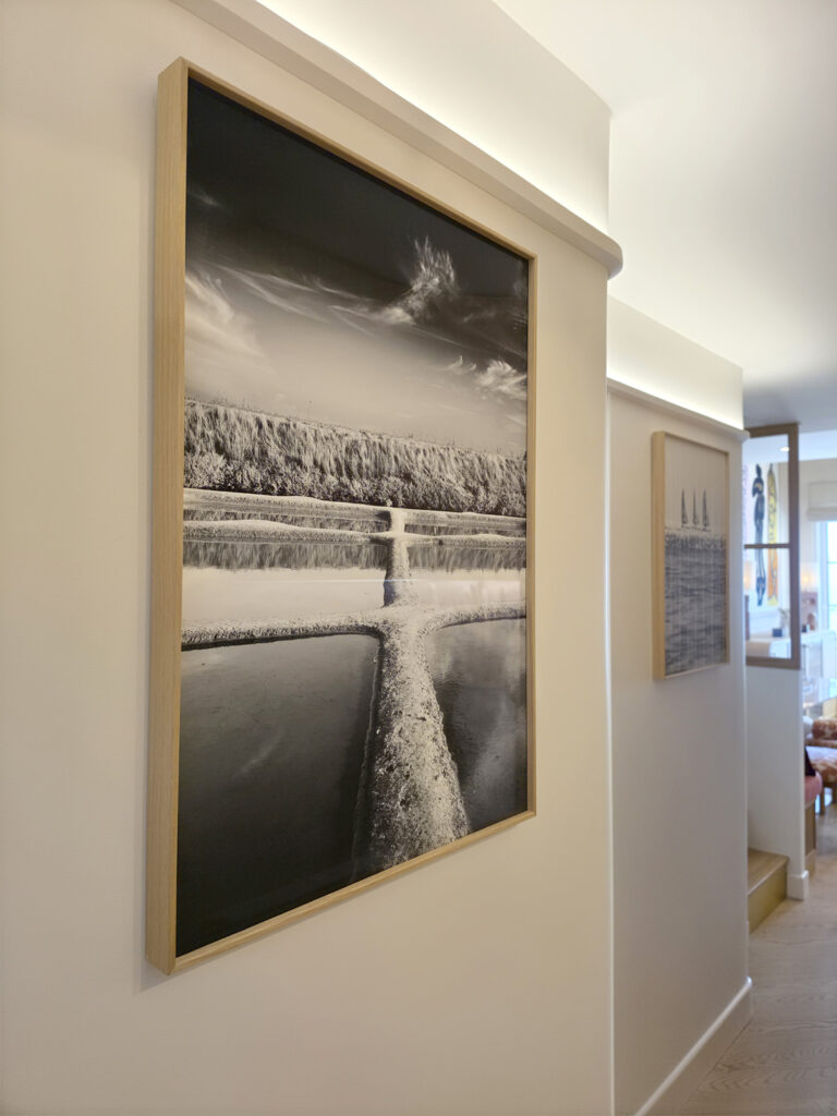 Photographie d'art en noir et blanc des marais salants par Yann Lecomte encadrée dans un couloir rénové par Studio Vesta.