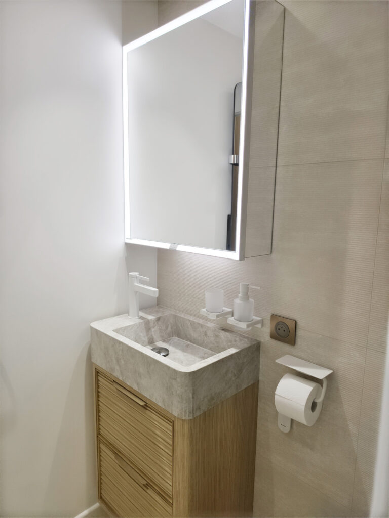 Meuble vasque en chêne strié et marbre surmonté d'une armoire de toilette miroir rétroéclairée à LED.