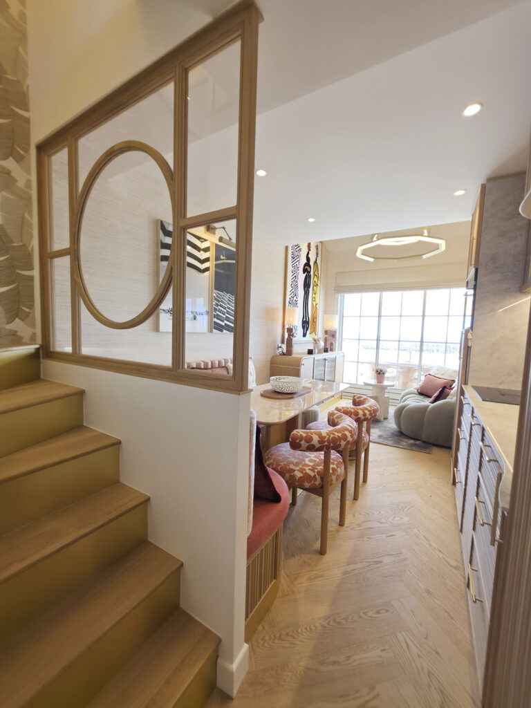Escalier habillé de bois et cuivre jouxtant une verrière sur mesure et ouvrant sur le coin repas et le salon vue mer.